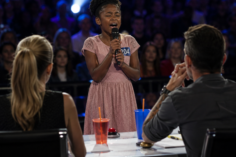 SHE CAME WITH $150 IN COINS AND A SONG THAT COULD SAVE HER MOTHER’S LIFE. THE WOMAN AT THE REGISTRATION TABLE LOOKED AT HER LIKE SHE WAS DIRT. BUT ACROSS THE ROOM, ONE JUDGE STOPPED BREATHING WHEN HE SAW THE LITTLE GIRL’S FACE.